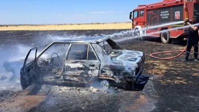 Şanlıurfa’nın Siverek ilçesinde tarlada park halinde olan otomobil yanarak kullanılamaz